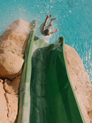 a person jumping into a water slide
