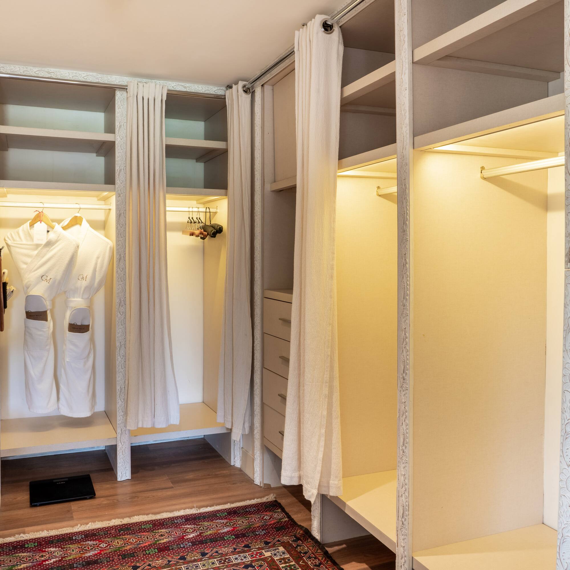 a closet with white curtains and shelves