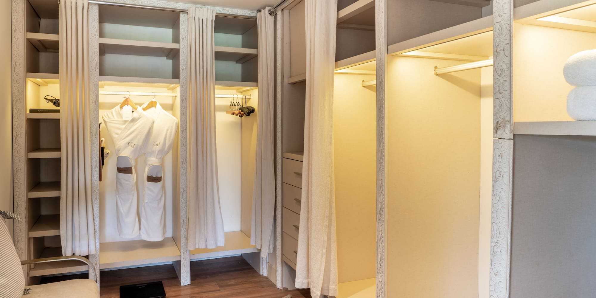 a closet with white curtains and shelves
