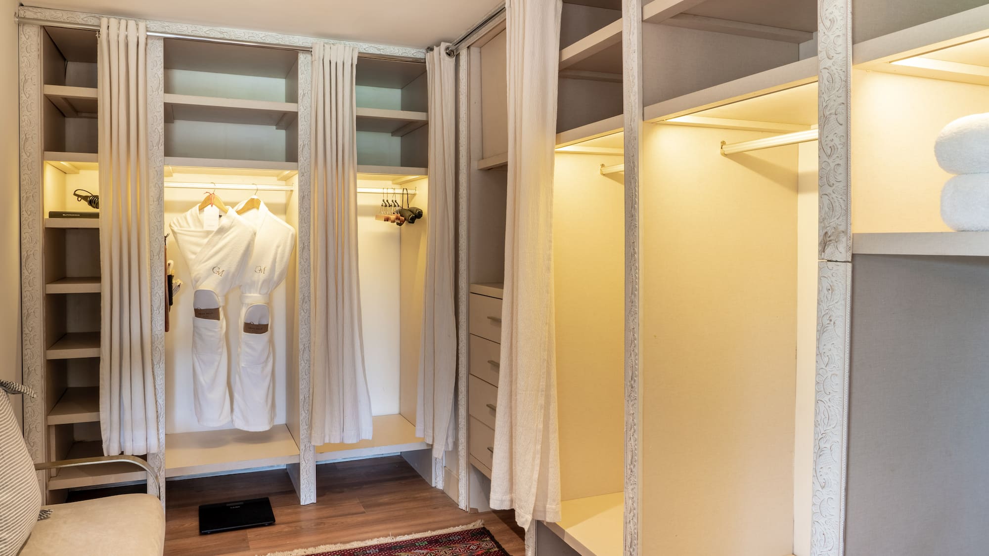a closet with white curtains and shelves