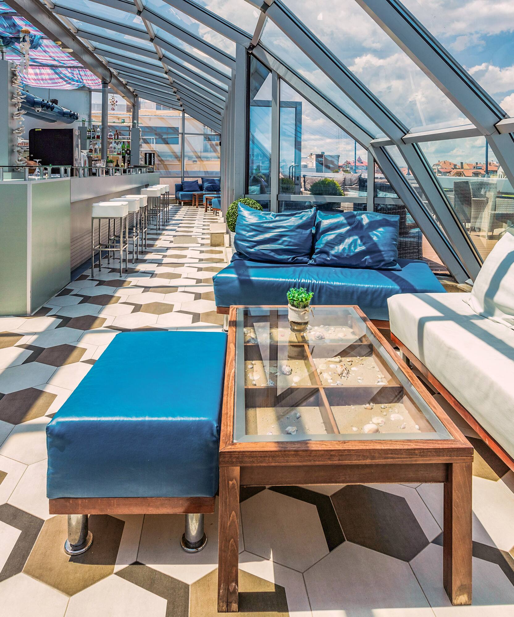 a room with a glass roof and a table and couches