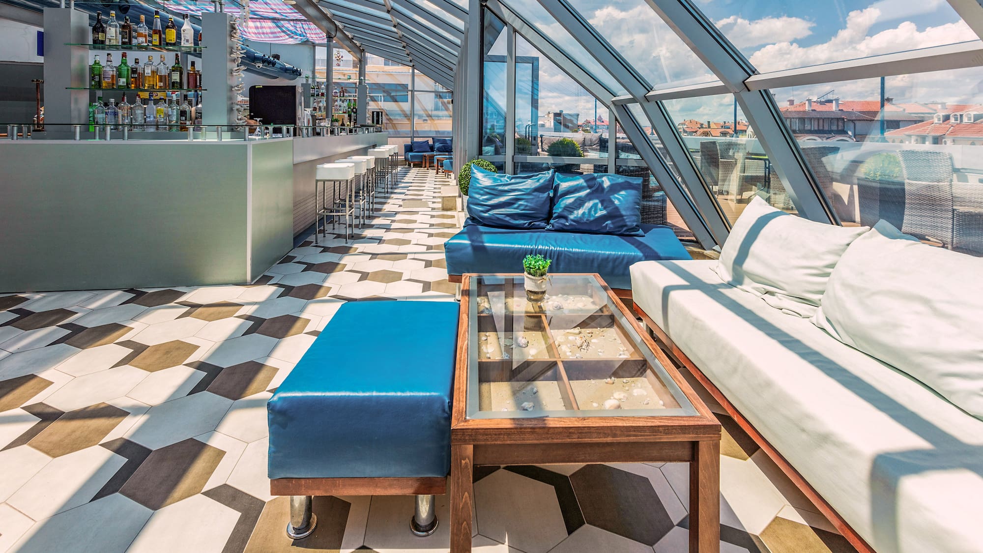 a room with a glass roof and a table and couches