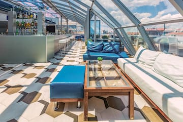 a room with a glass roof and a table and couches