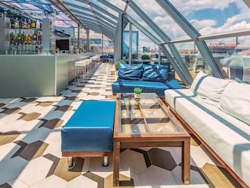 a room with a glass roof and a table and couches