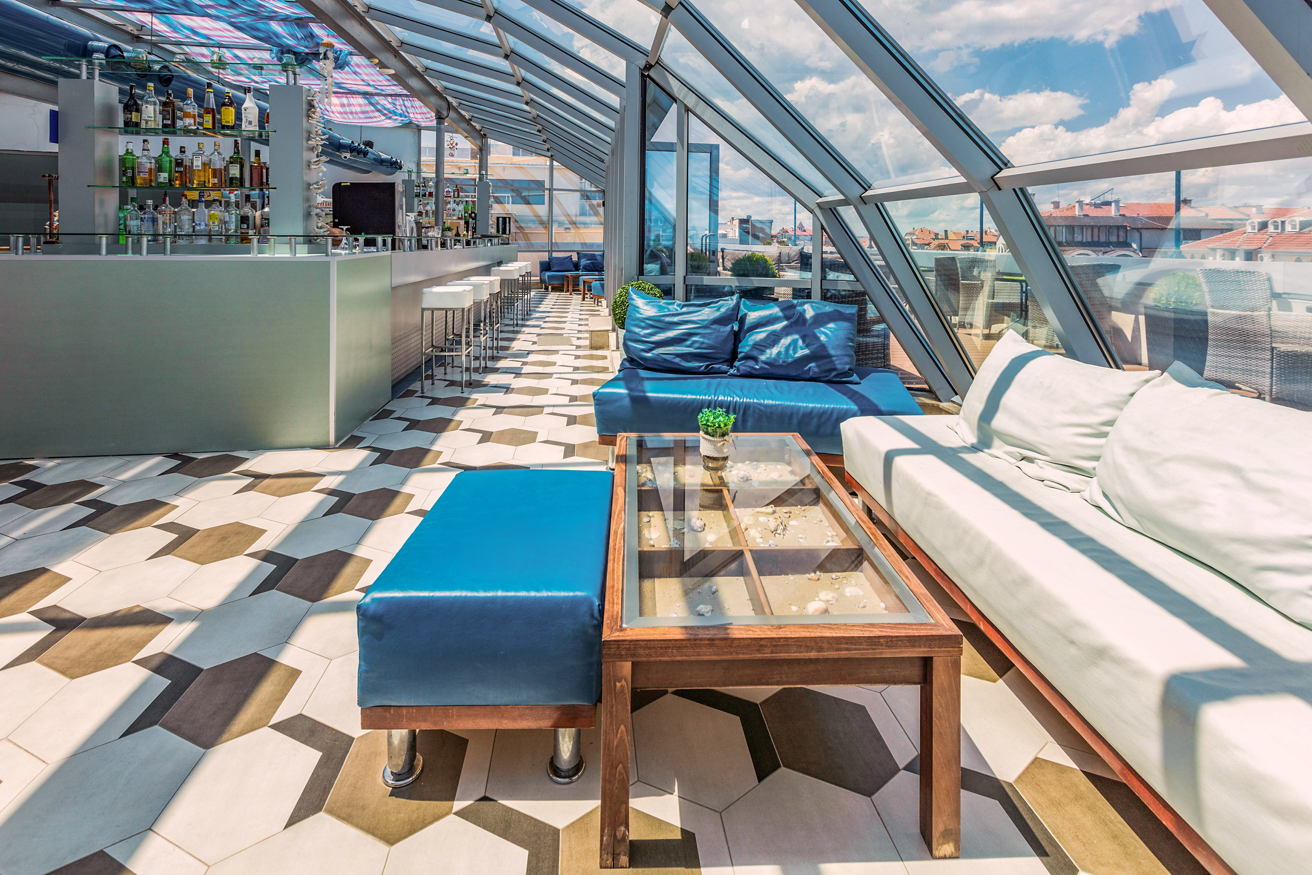 a room with a glass roof and a table and couches