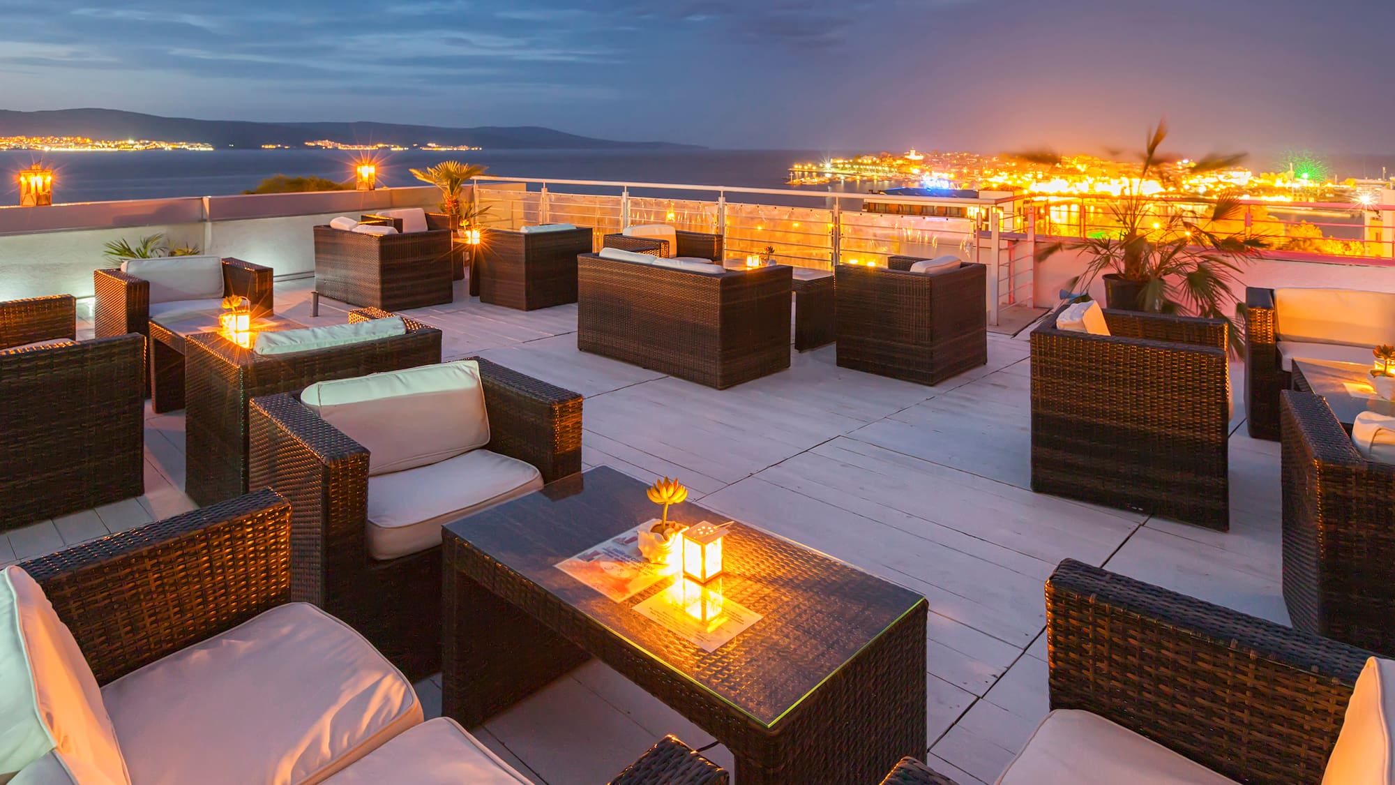 a patio with chairs and tables and lights on the deck