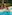 Couple and child relaxing poolside in a tropical resort with an inflatable float.