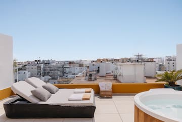 a hot tub on a rooftop with a couch and a hot tub