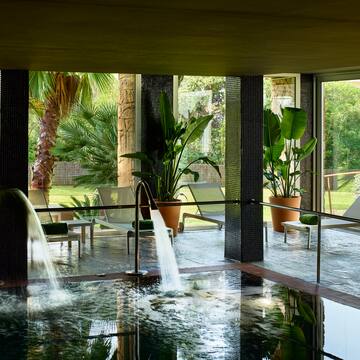 a pool with a waterfall in the middle of it