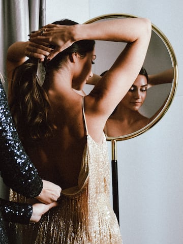 a woman in a dress looking at a mirror