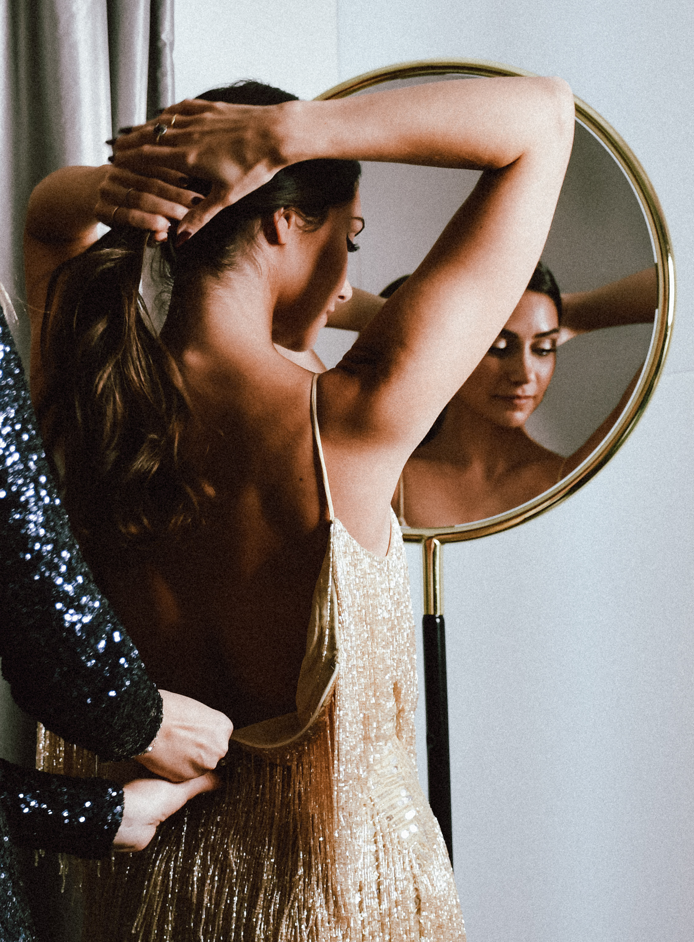 a woman in a dress looking at a mirror