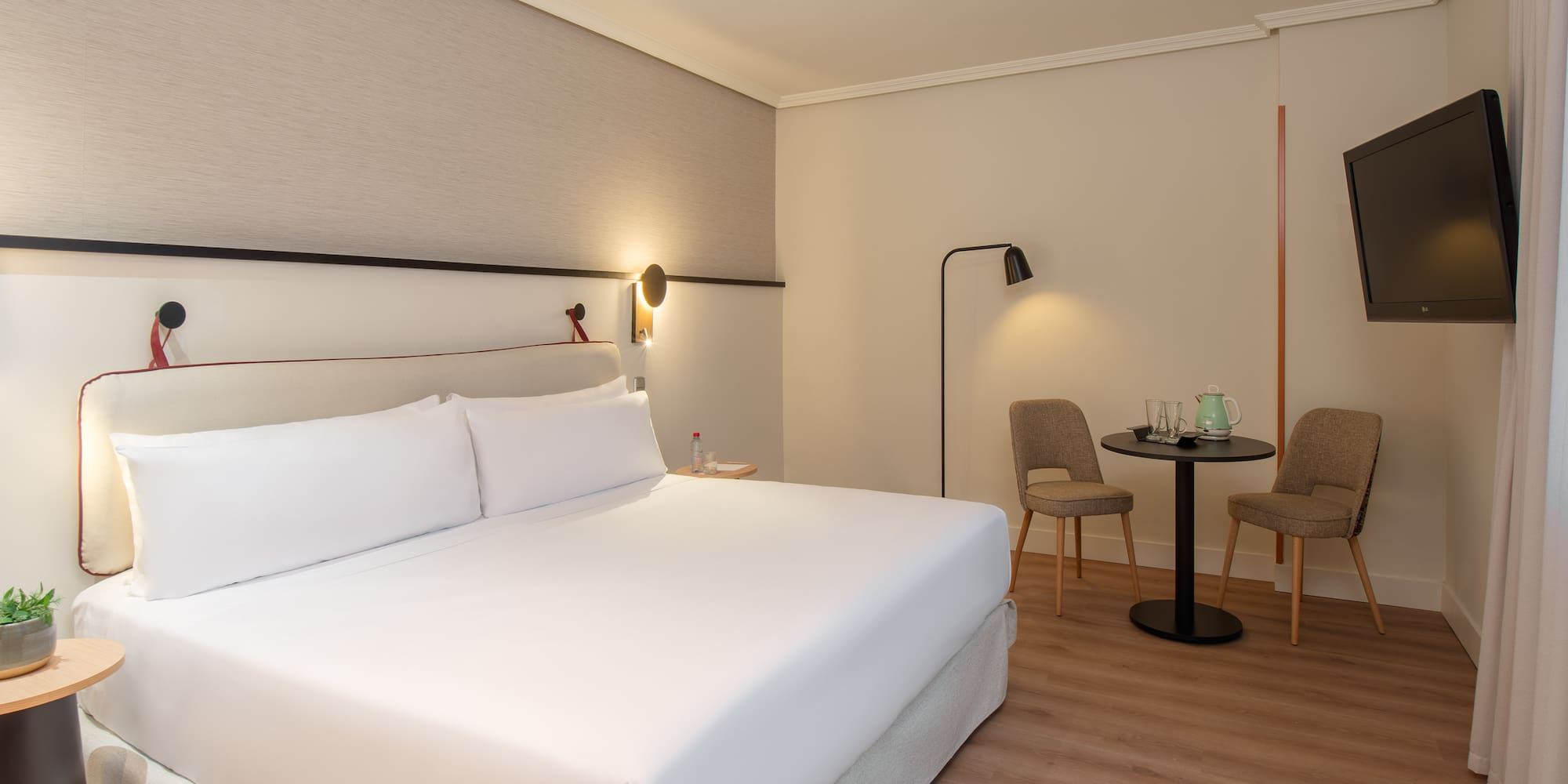 a hotel room with a bed and chairs