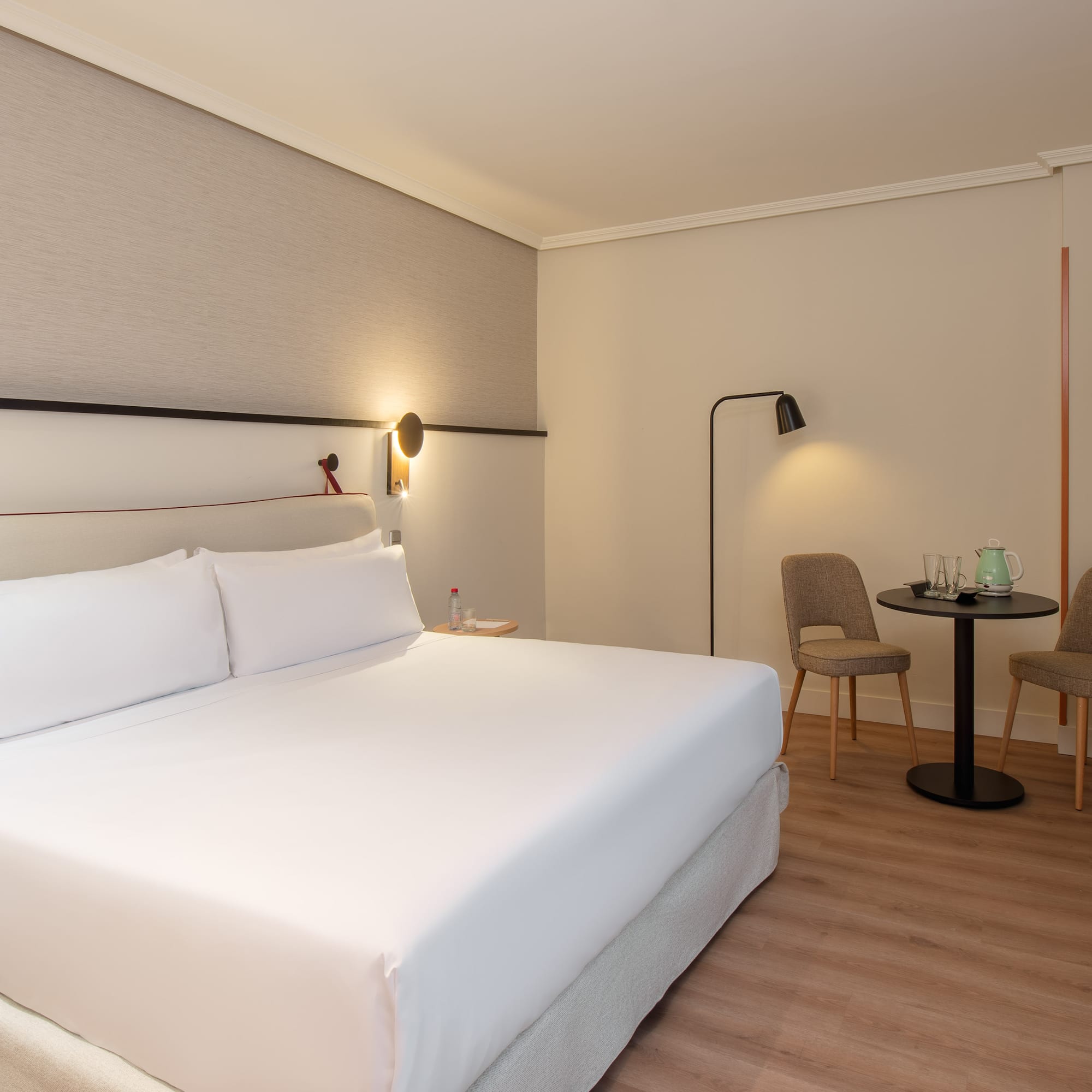 a hotel room with a bed and chairs