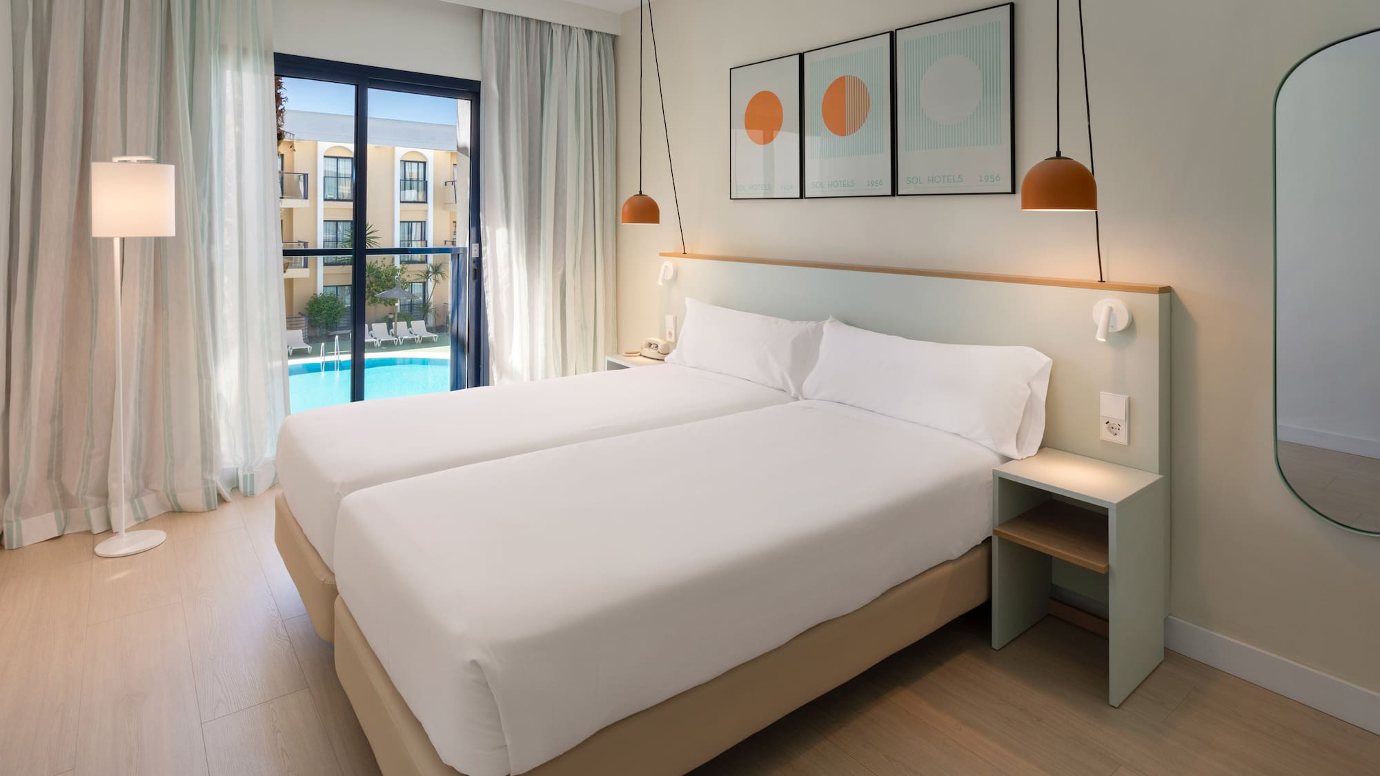 a room with two beds and a pool in the background