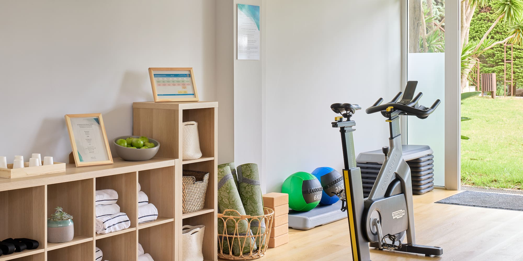 a room with exercise bikes and shelves with towels