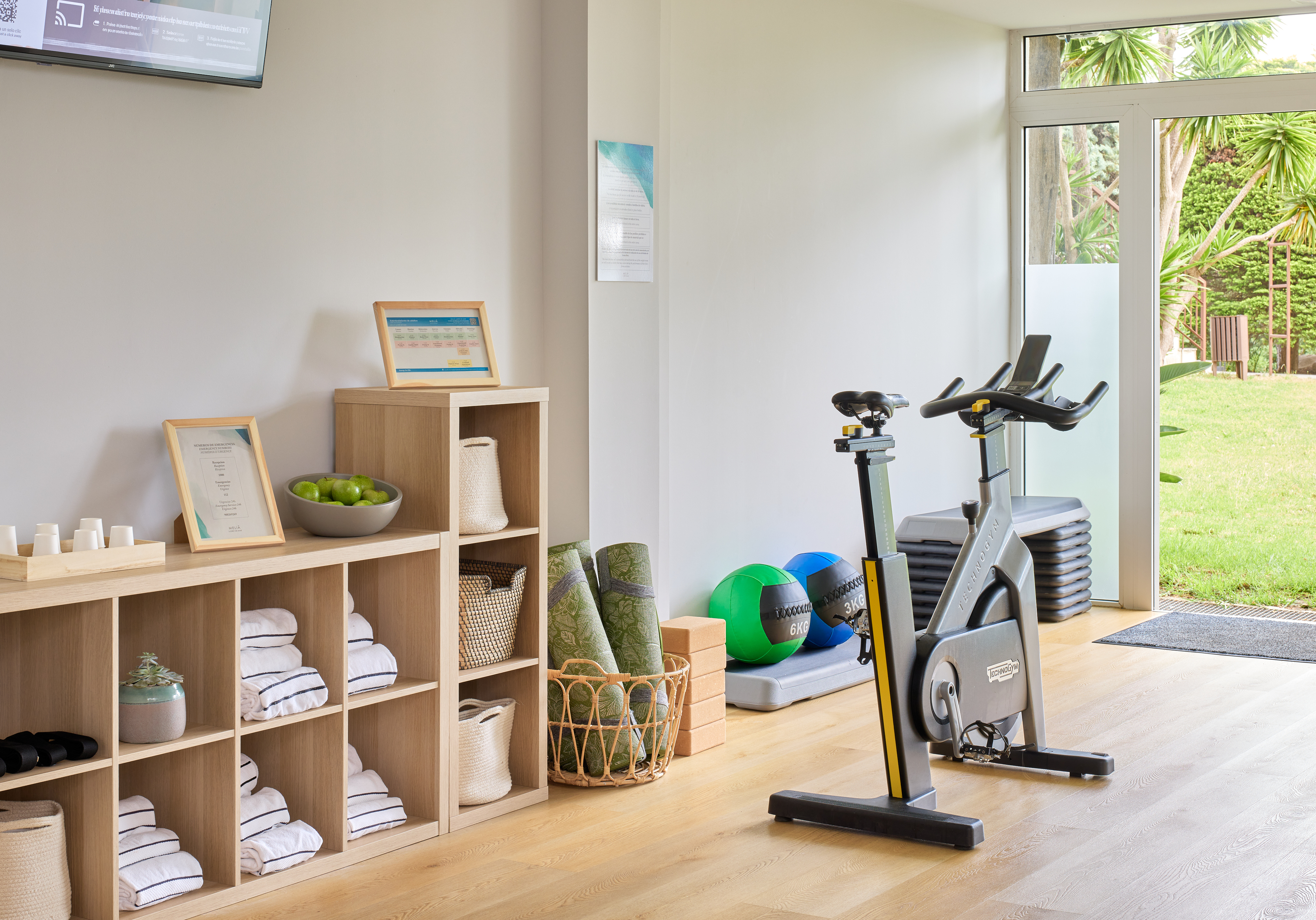 a room with exercise bikes and shelves with towels