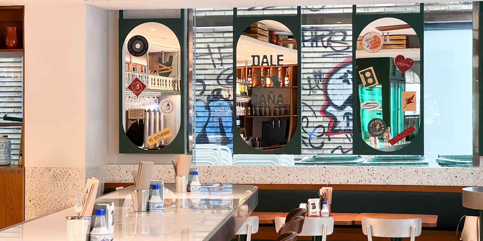 a bar with a white counter and chairs