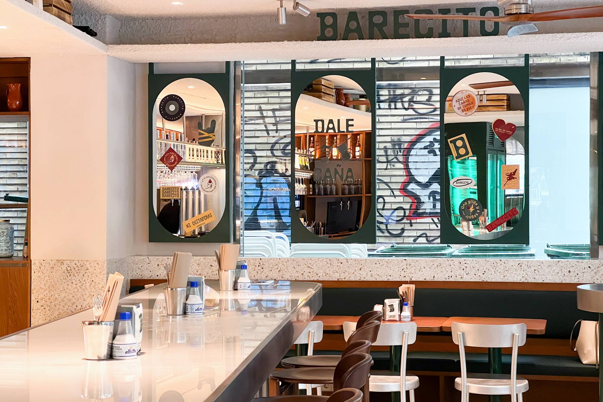Modern 'BARECITO' bar interior with white counter and stools.
