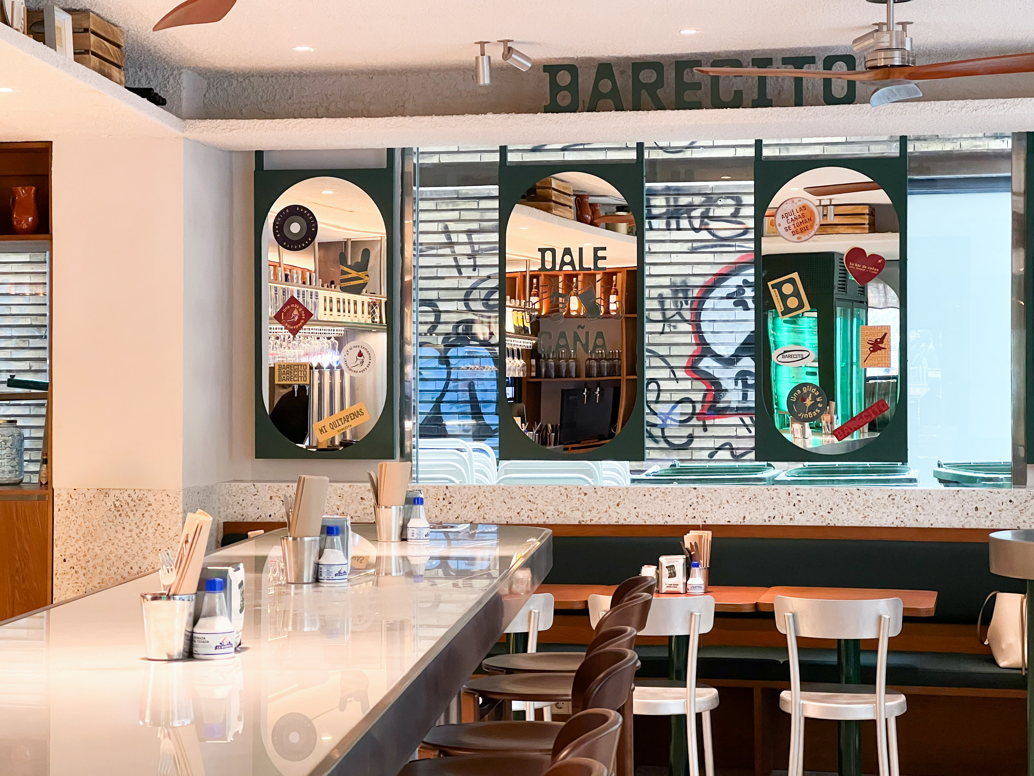 a bar with a white counter and chairs