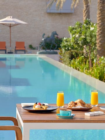 a table with food and drinks on it by a pool
