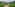 Winding road through green terraced rice fields, rural village, misty mountains.