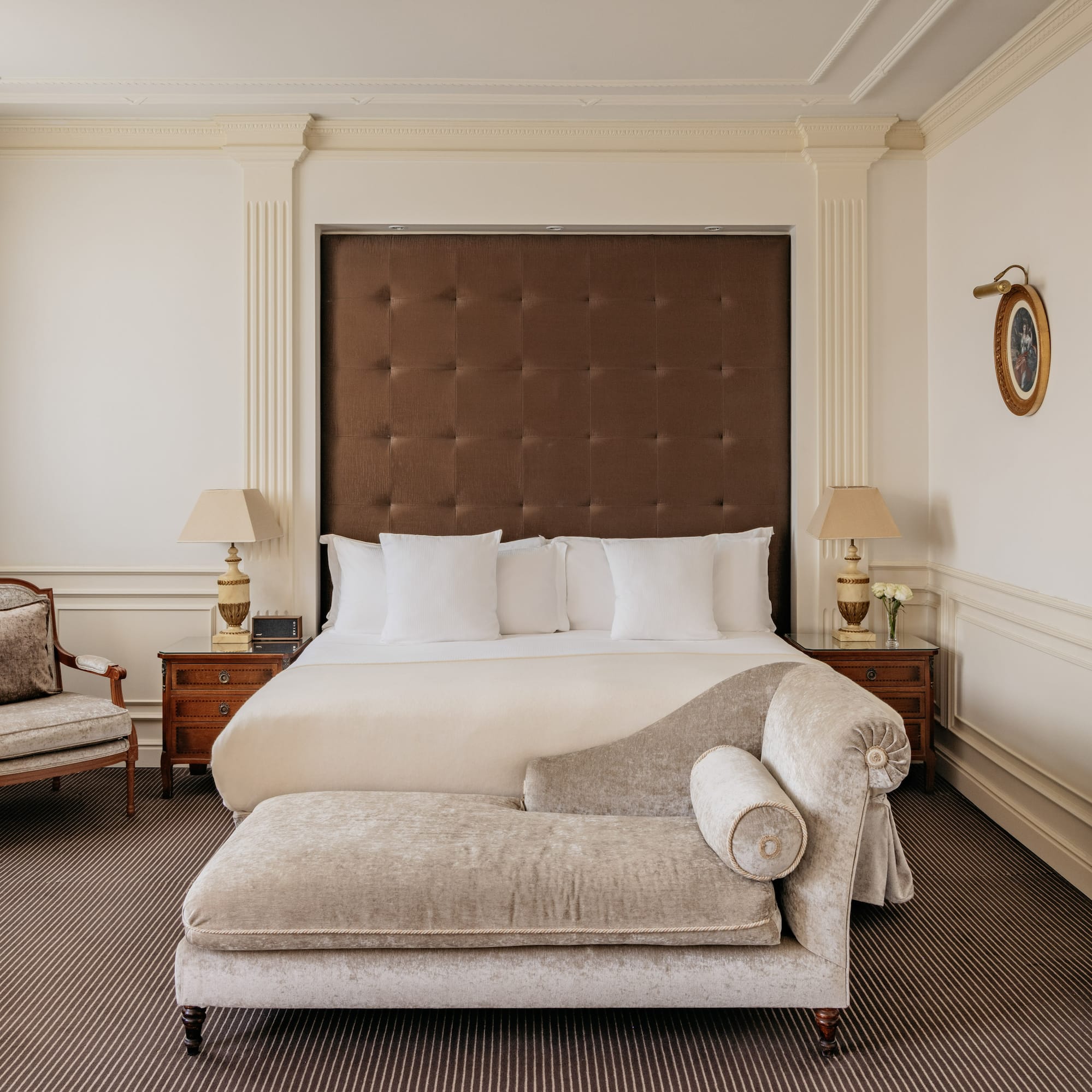 a bedroom with a bed and a chaise lounge