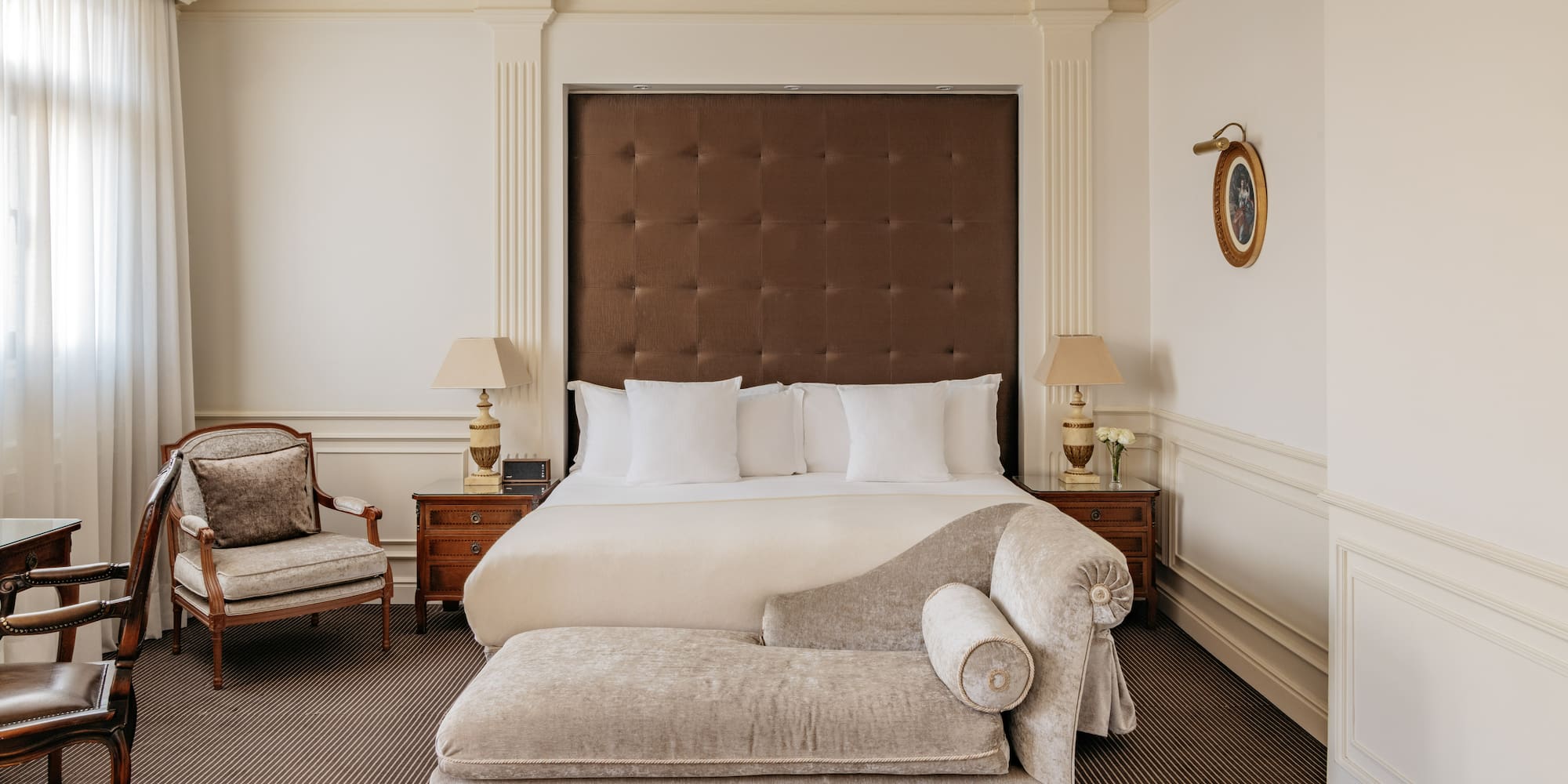 a bedroom with a bed and a chaise lounge