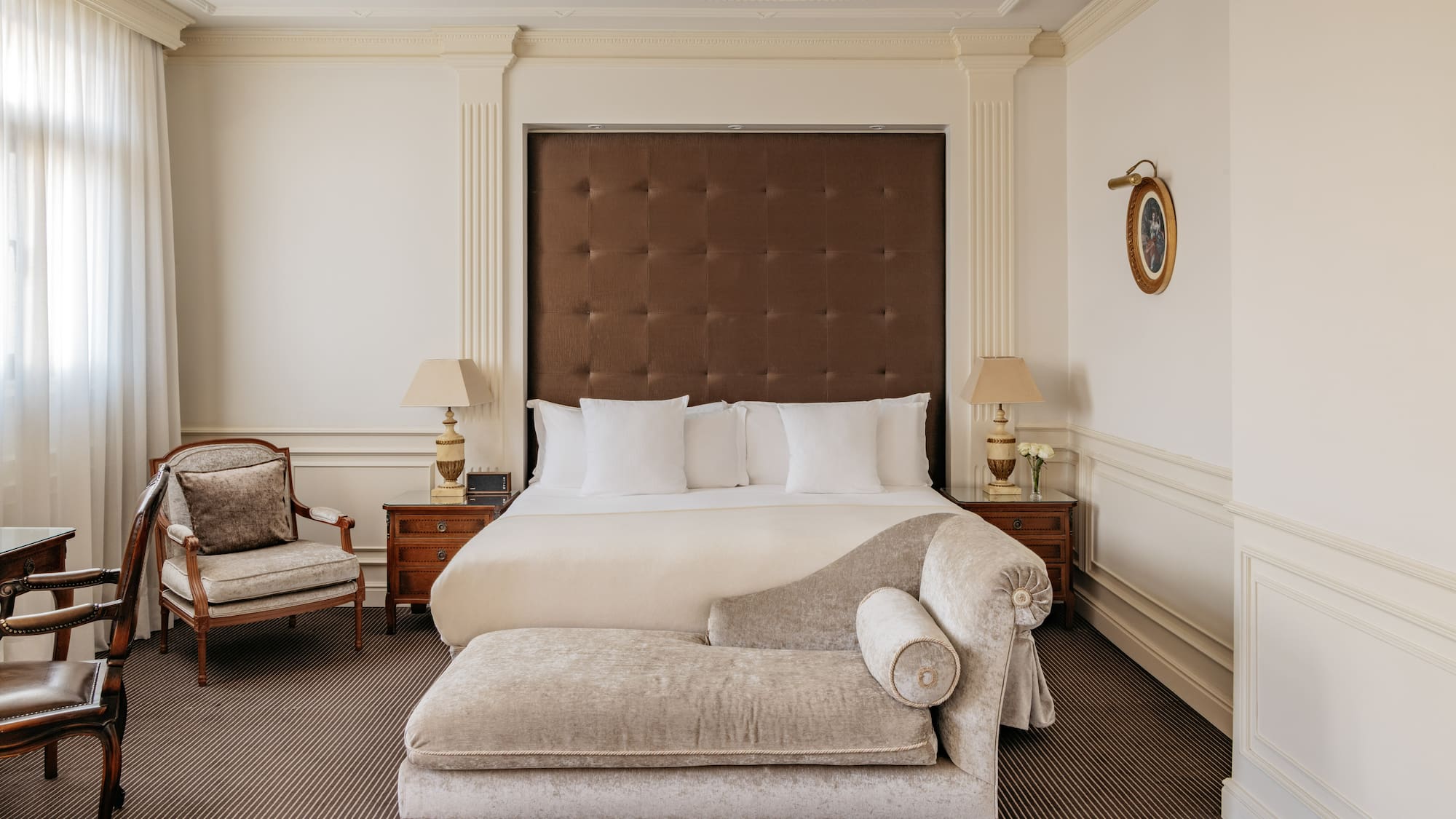 a bedroom with a bed and a chaise lounge