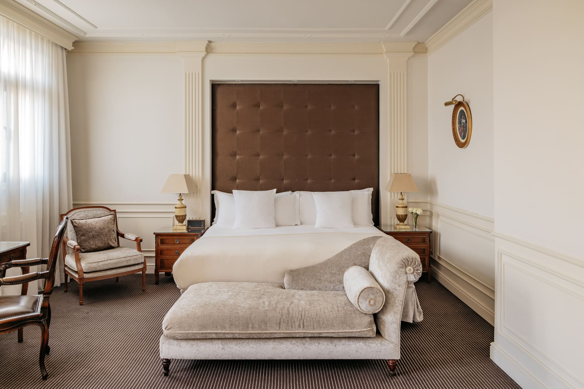 a bedroom with a bed and a chaise lounge