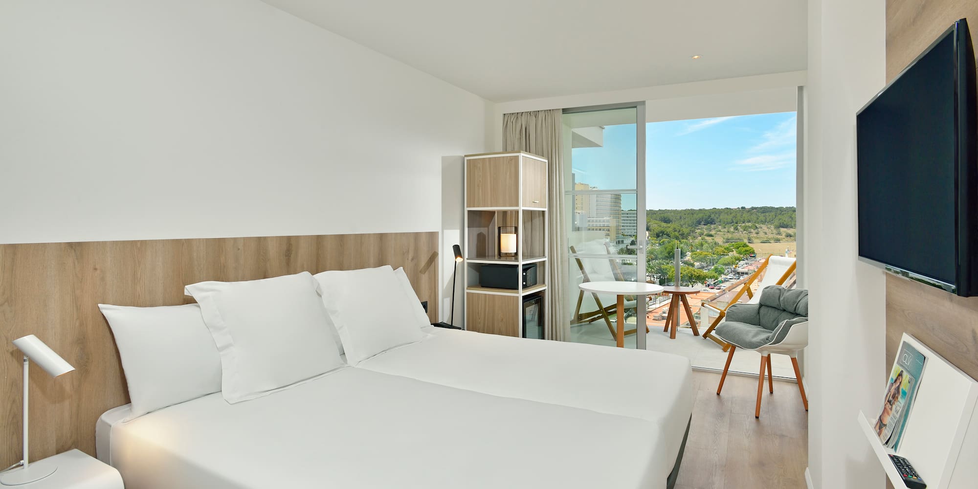 a room with a large bed and a chair and a table