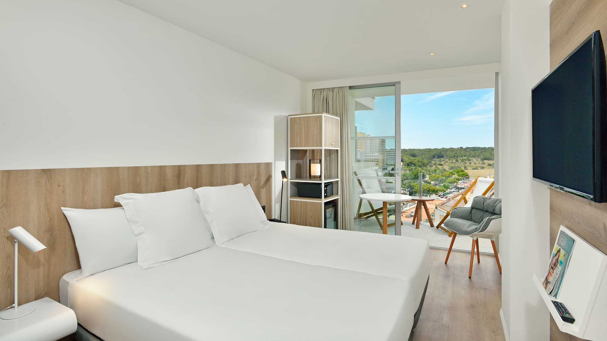 a room with a large bed and a chair and a table