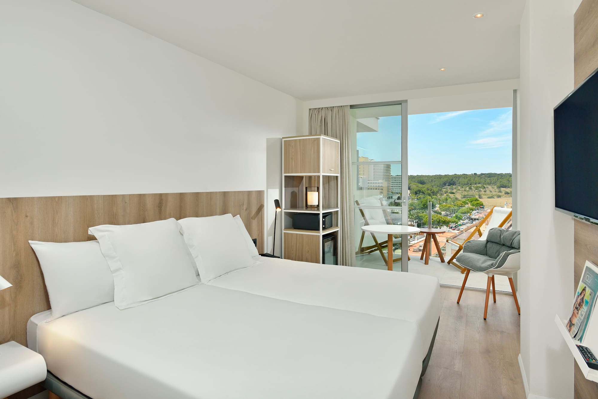 a room with a large bed and a chair and a table