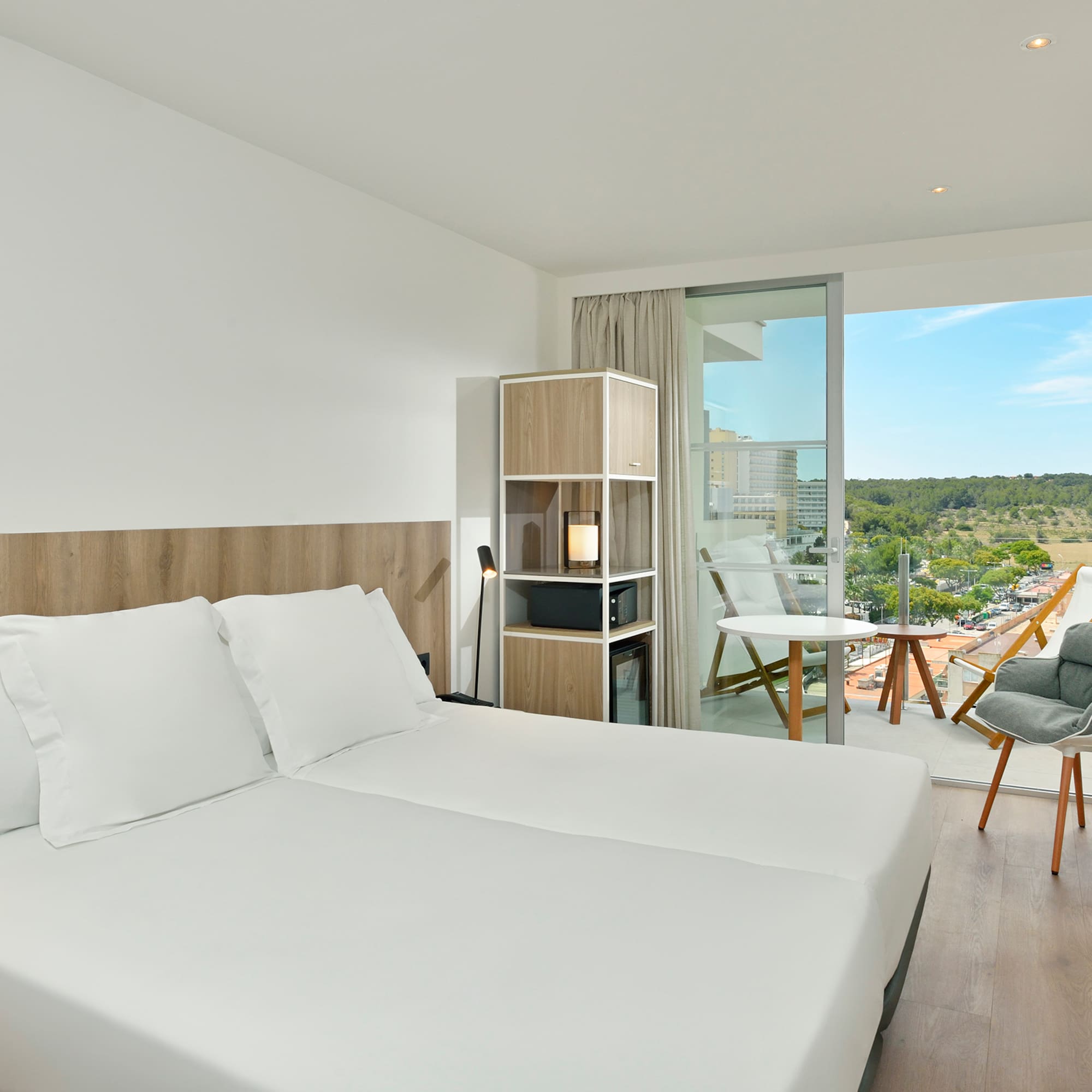 a room with a large bed and a chair and a table