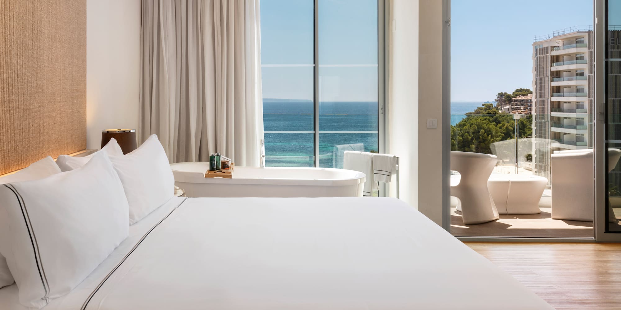 a bedroom with a bathtub and a tub and a large window