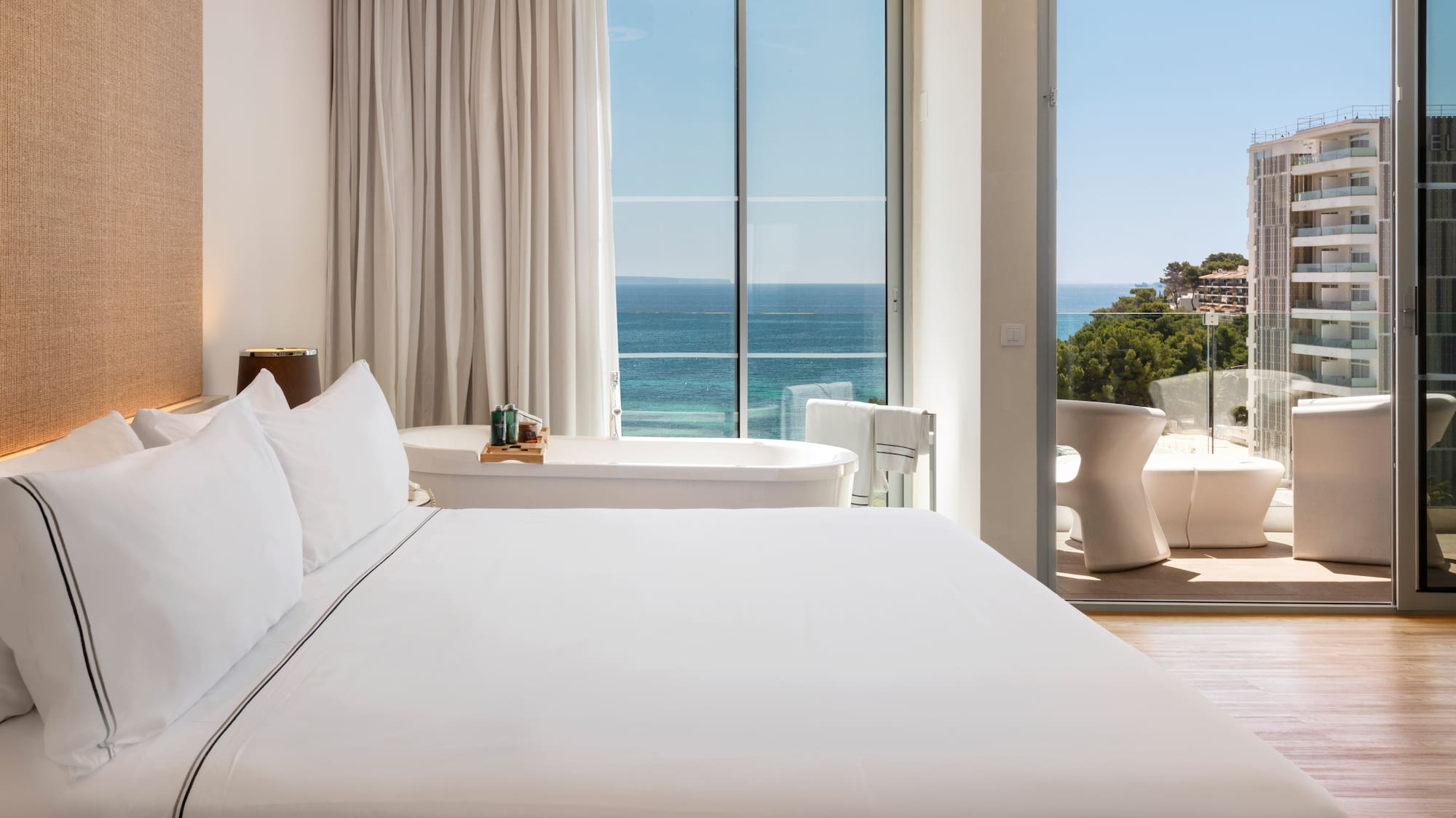 a bedroom with a bathtub and a tub and a large window