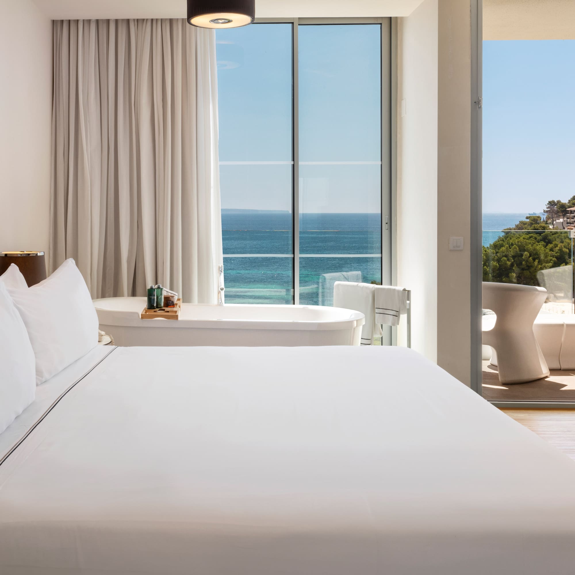 a bedroom with a bathtub and a tub and a large window