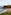 Tynemouth Priory & Castle ruins on cliff, sandy beach below, lighthouse.