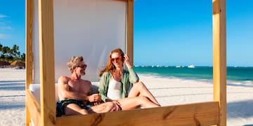 a man and woman sitting on a beach