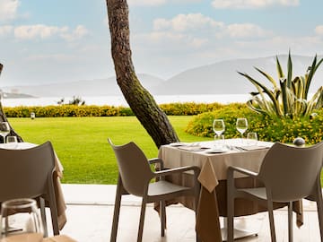 a table set up with chairs and a tree in the background