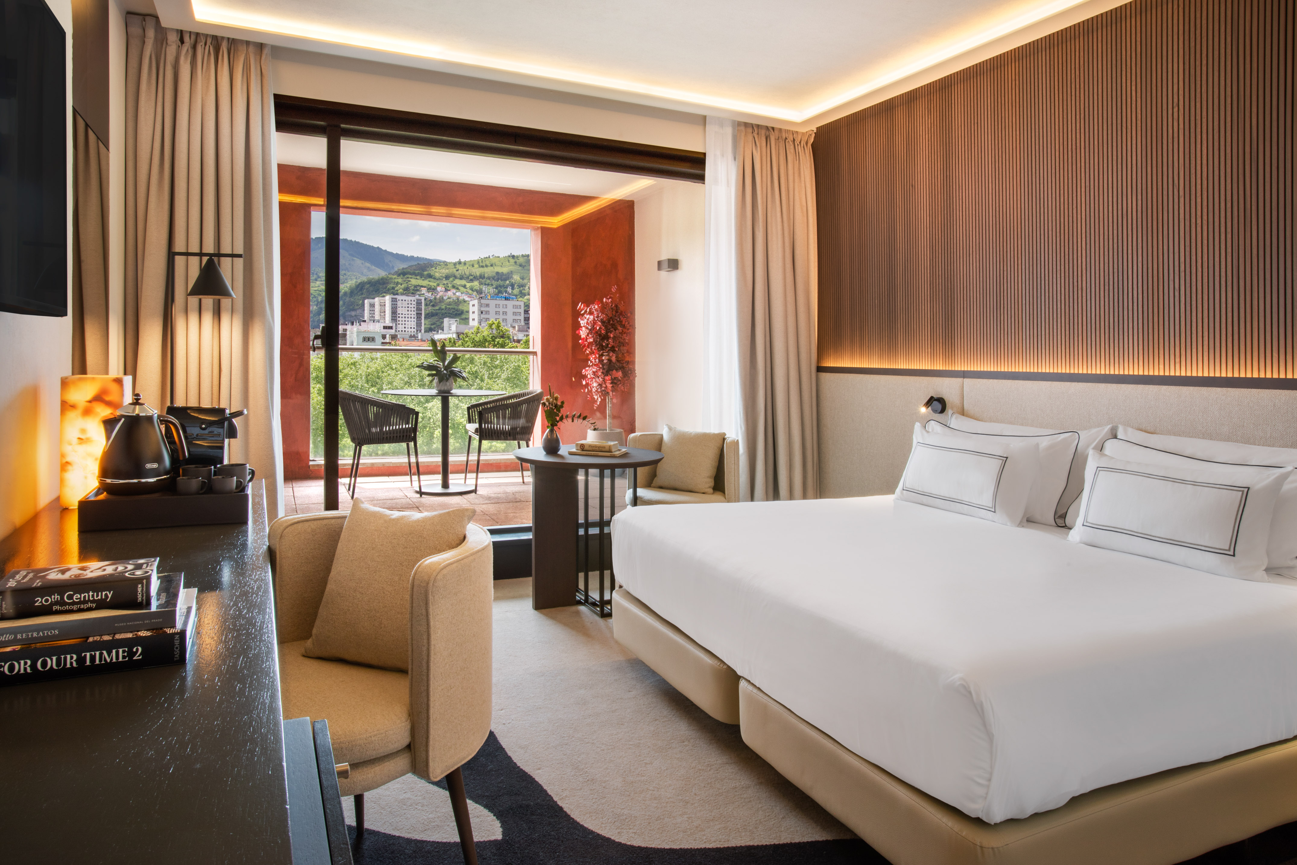 Luxury hotel room with balcony, mountain views, king bed, and modern design.