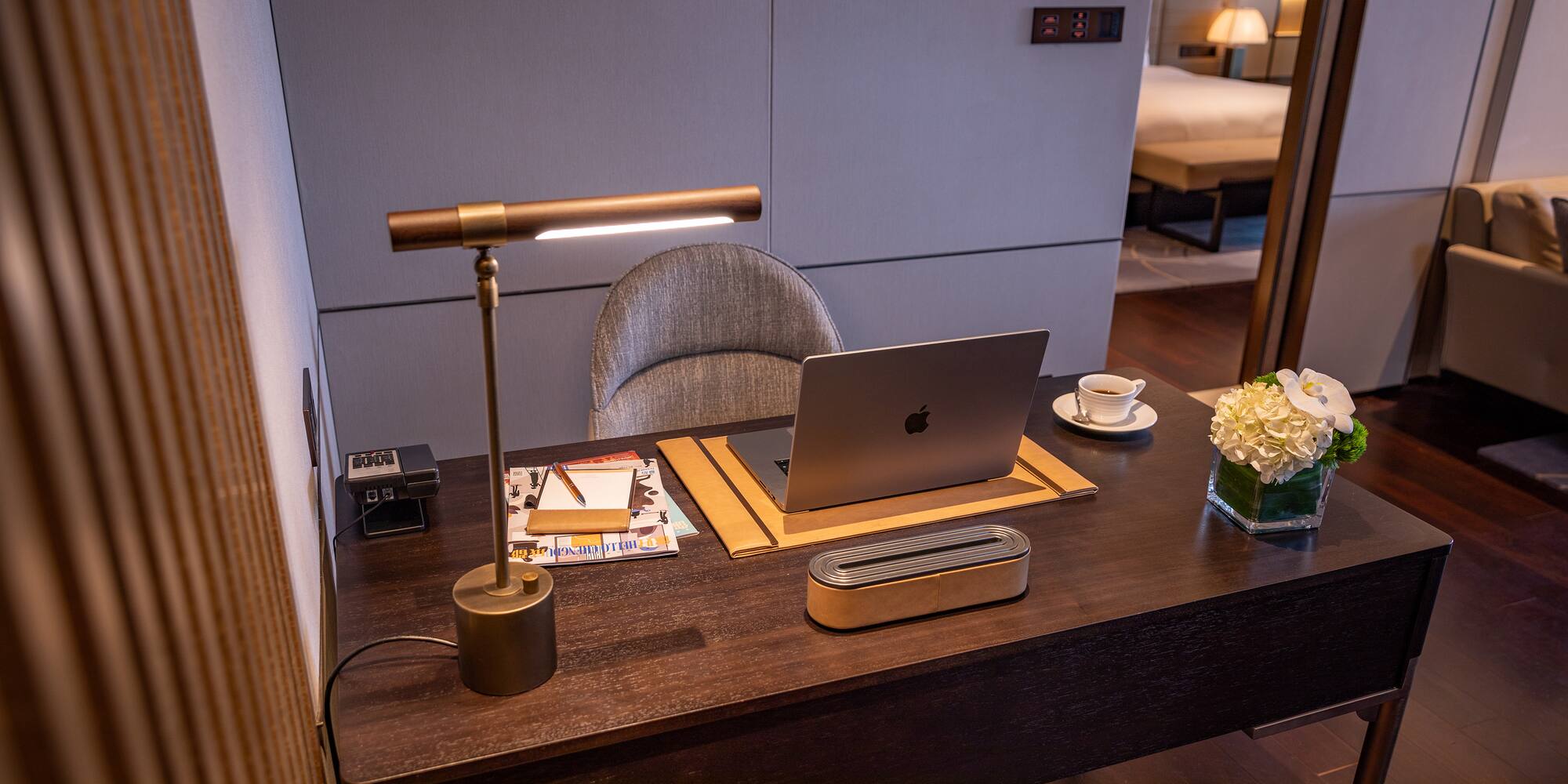 a desk with a laptop and a lamp
