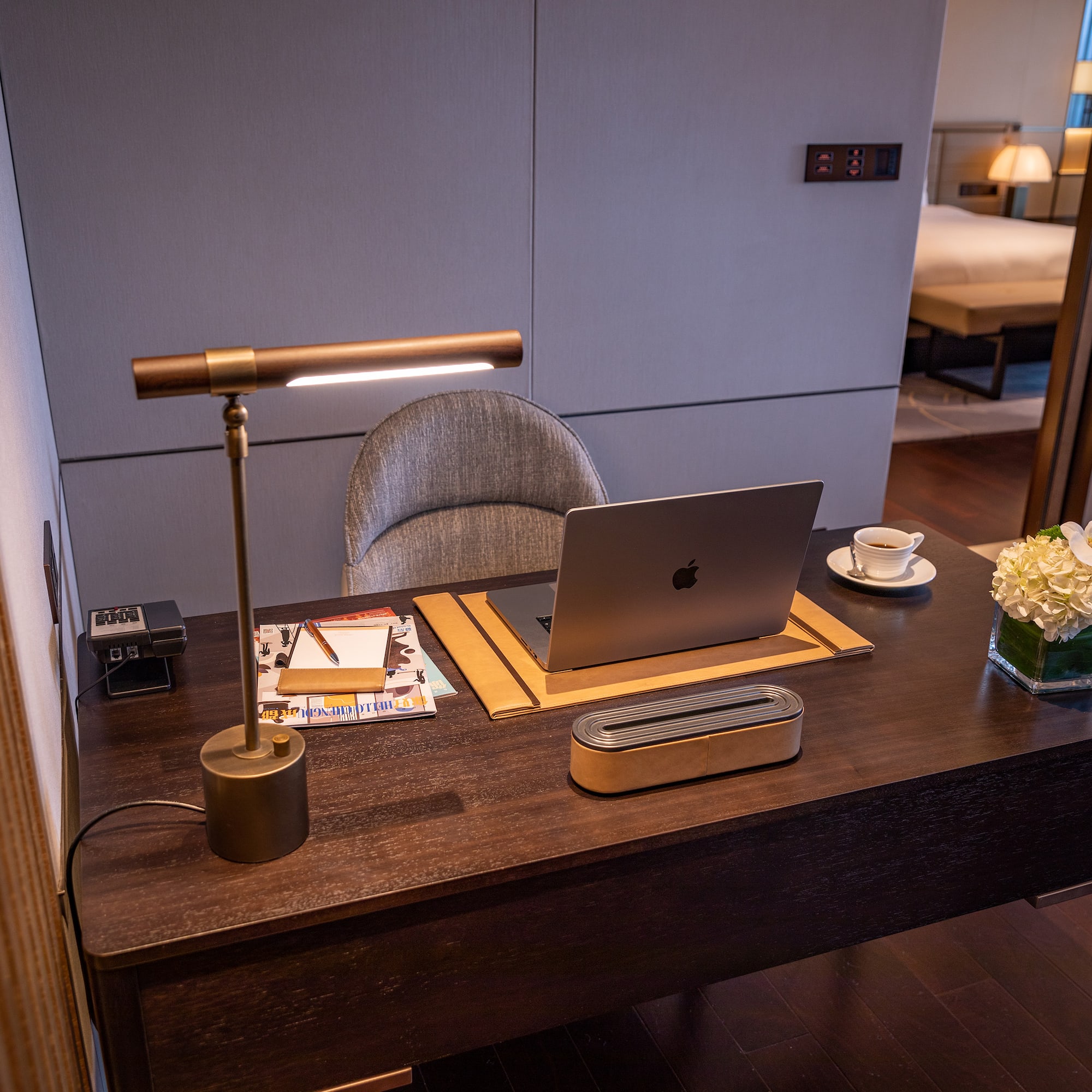 a desk with a laptop and a lamp
