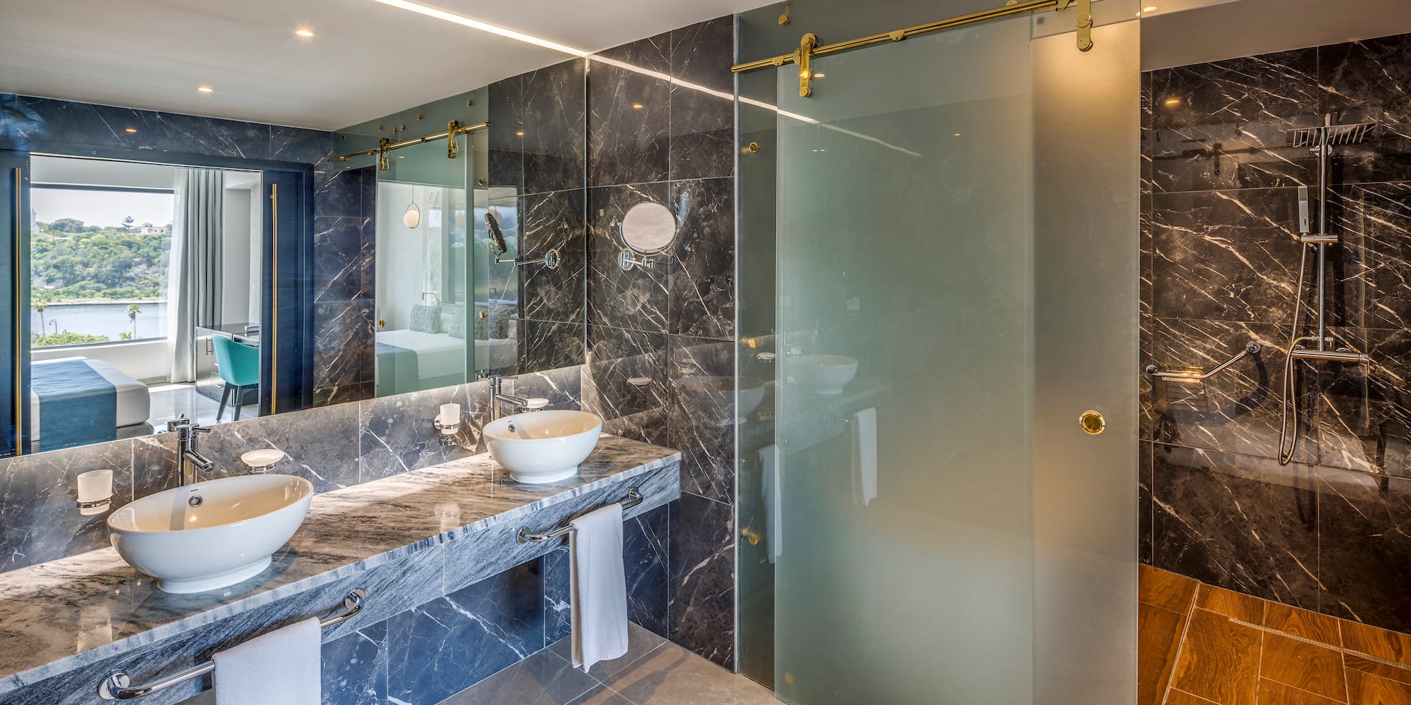 a bathroom with marble countertops and a glass shower