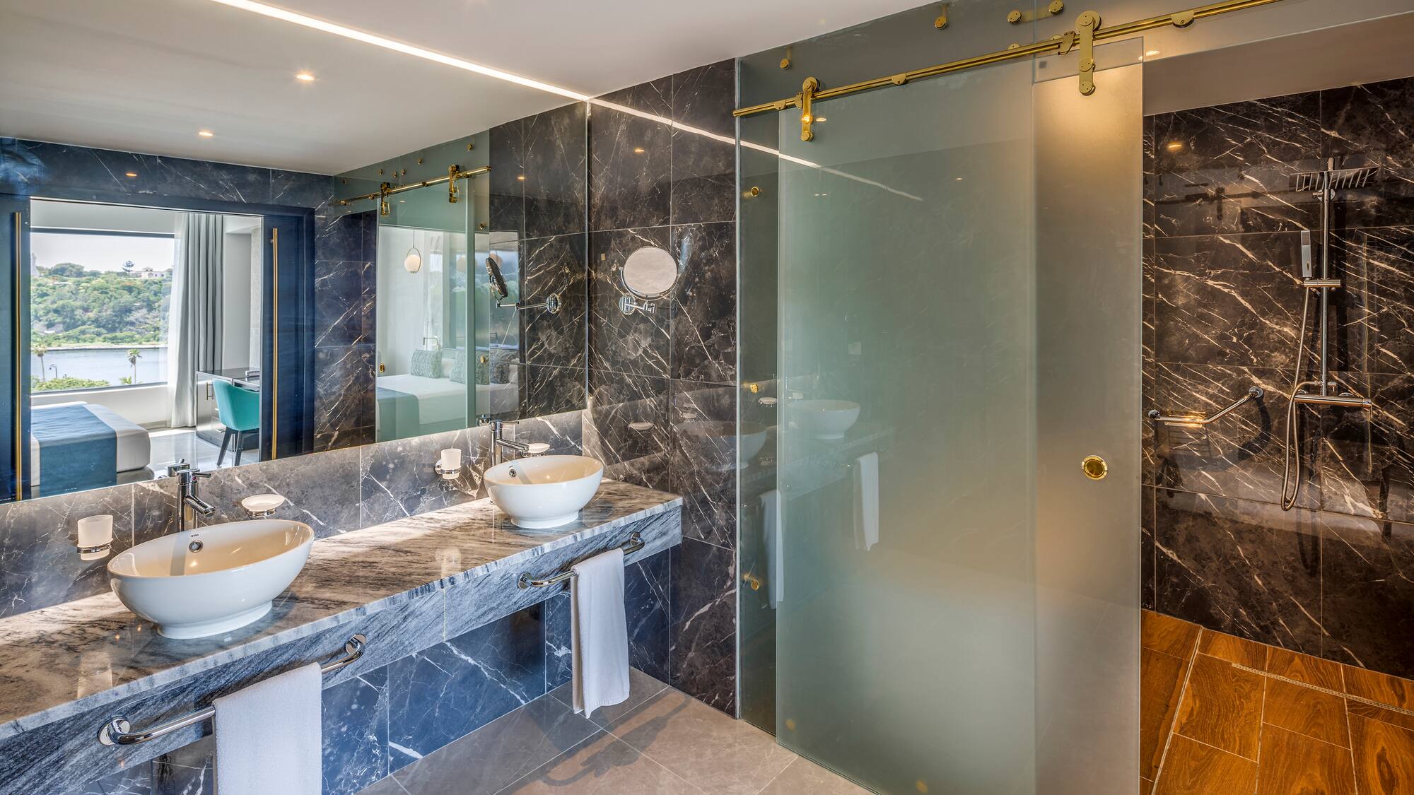 a bathroom with marble countertops and a glass shower