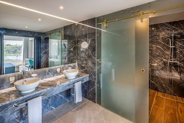a bathroom with marble countertops and a glass shower