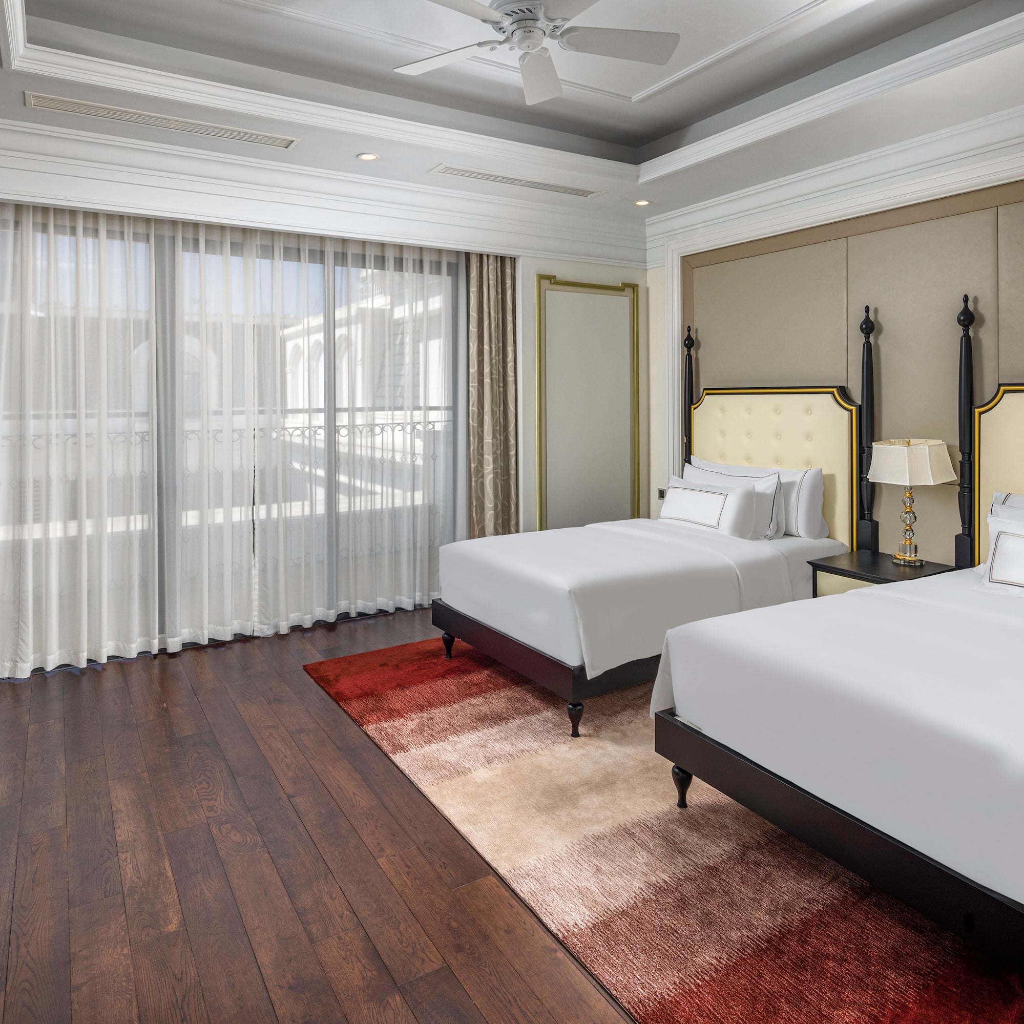 une chambre avec deux lits et un ventilateur de plafond