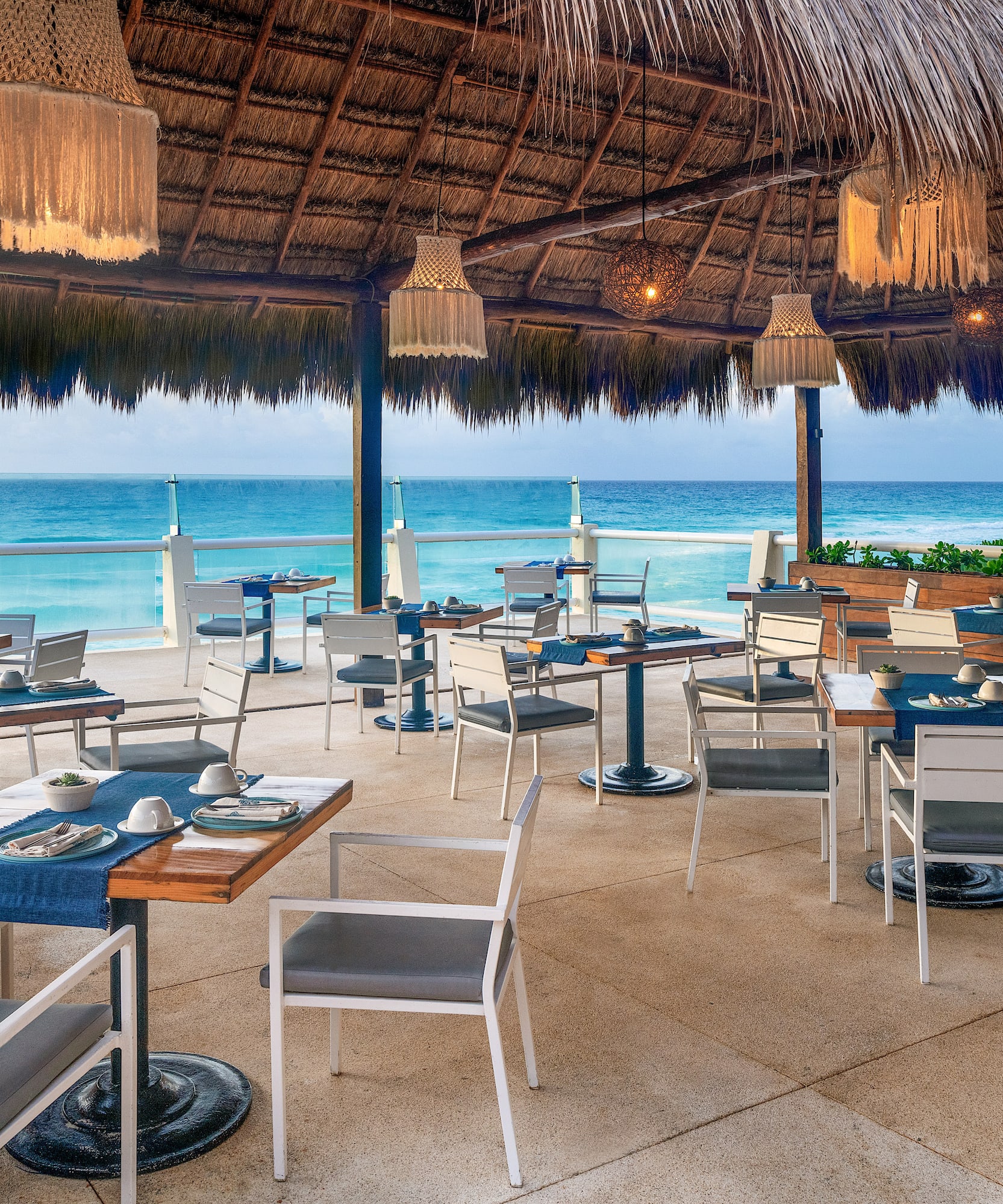 a restaurant with a thatched roof and tables and chairs