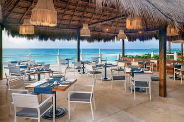 a restaurant with a thatched roof and tables and chairs