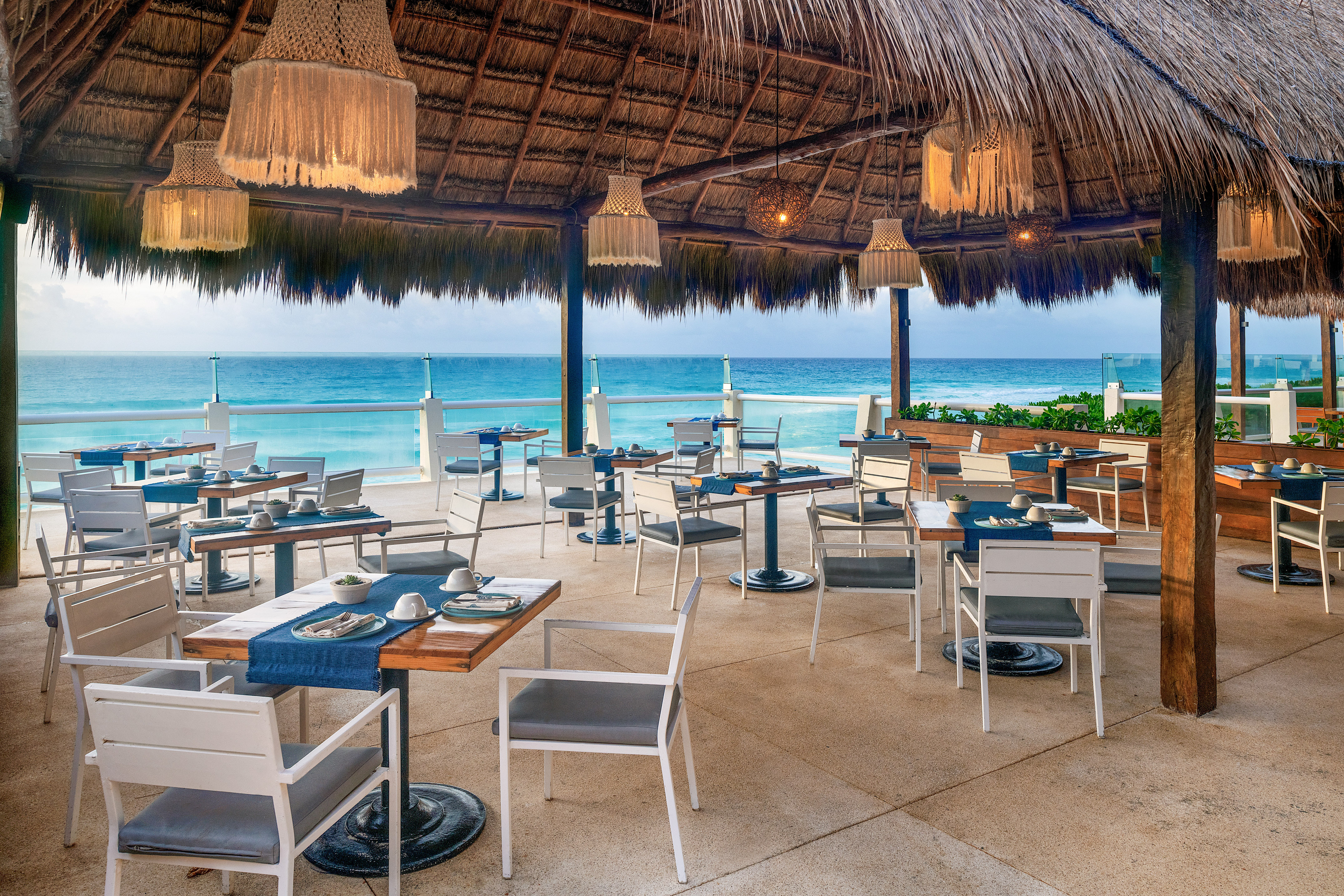 a restaurant with a thatched roof and tables and chairs