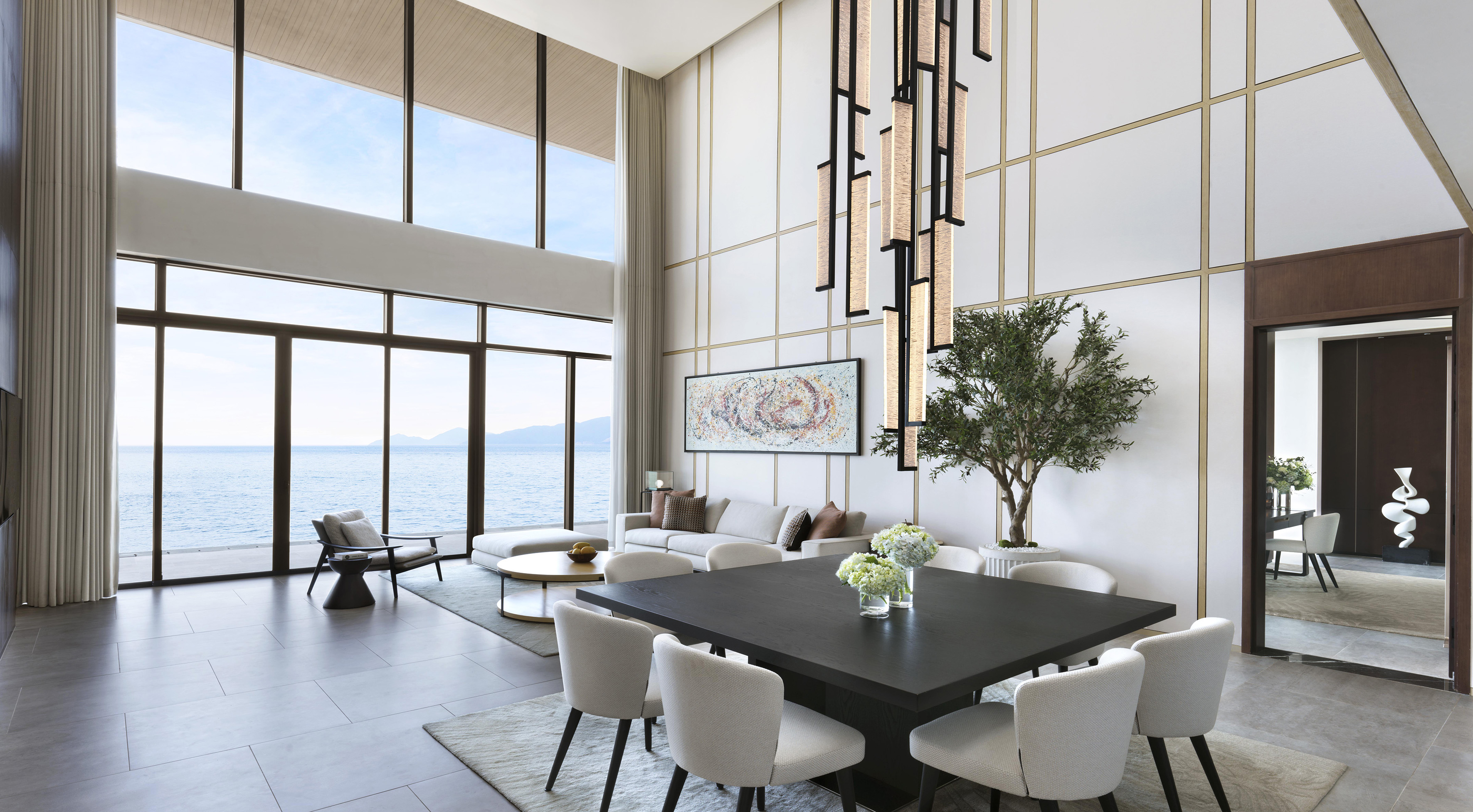 Luxurious modern living and dining room with floor-to-ceiling ocean views.